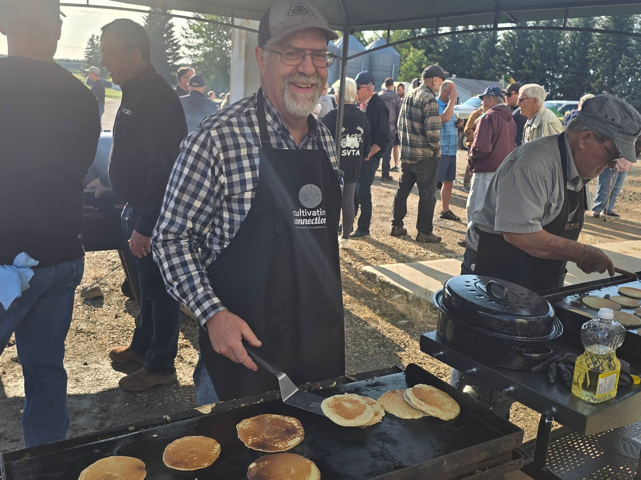 A volunteer turning pancakes on the griddle